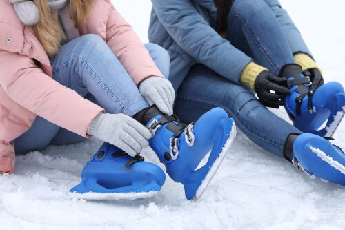 Twee mensen trekken ijshockeyschaatsen aan